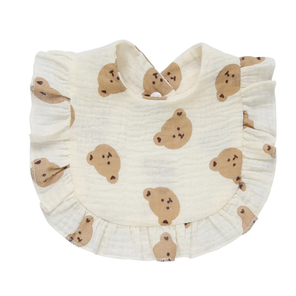 Cream baby bib with bear faces and ruffled edges.