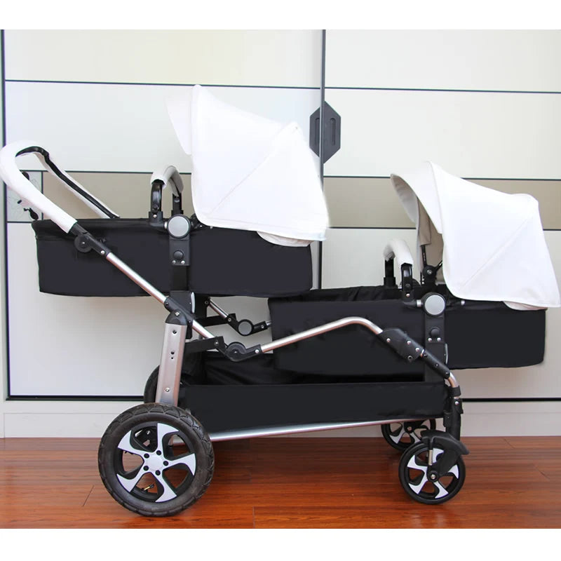 Side view of a tandem double stroller with black seats and white canopies, featuring a sleek metal frame and four wheels, set indoors on a wooden floor.