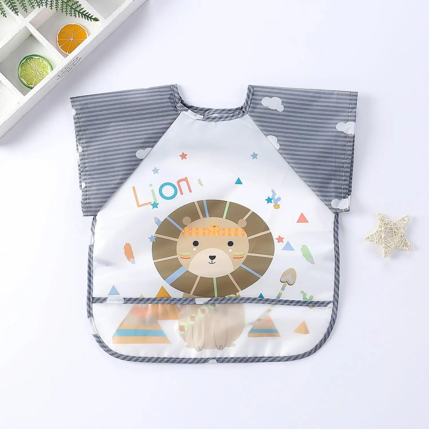 Children's bib with a lion design, colorful geometric shapes, and the word "Lion" text. It has gray striped sleeves with cloud patterns, displayed on a white background.