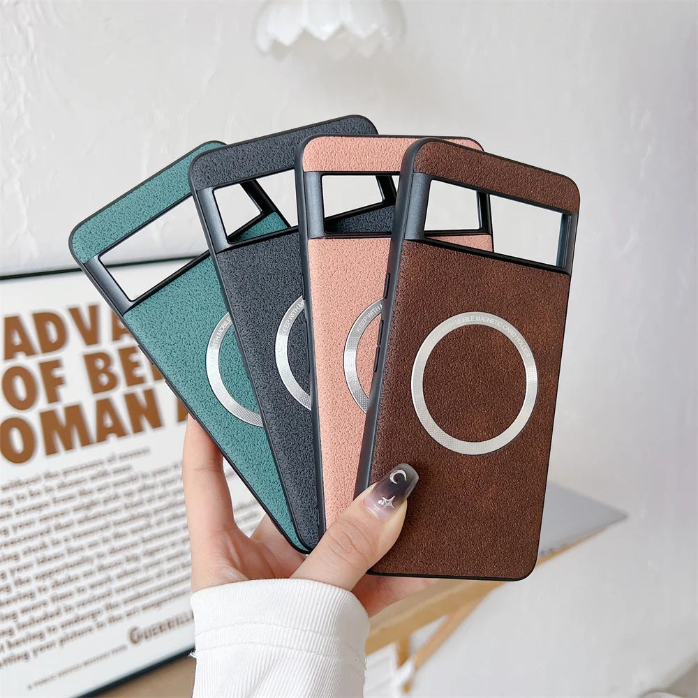 A hand holds four phone cases in green, black, pink, and brown, each with a circular design. A blurred poster and part of a white sleeve are visible in the background.