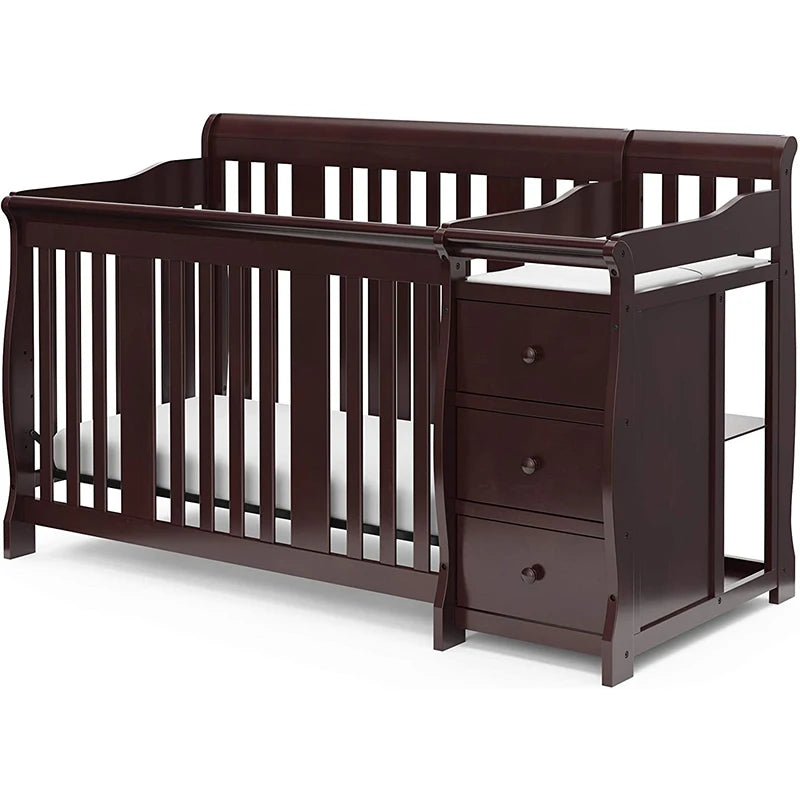 Dark wood crib with an attached changer, featuring three drawers and a safety rail. The crib has vertical slats and a mattress, combining functionality and elegant design.