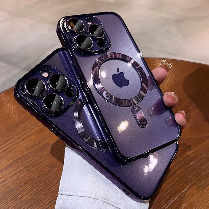 Two purple iPhones with glossy finishes are held in a hand. They feature prominent triple camera lenses and an Apple logo. The setting includes a wooden surface.