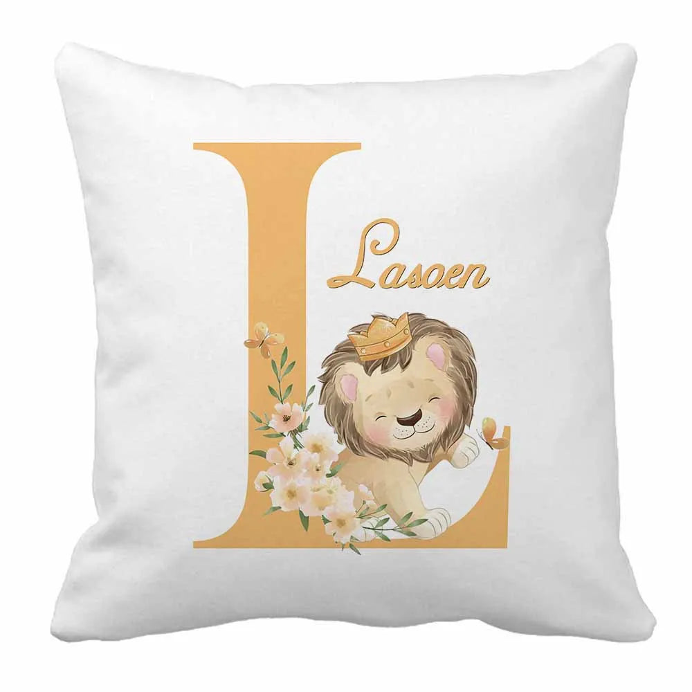 Cute lion with a crown nestled against a large letter "L" adorned with flowers. The word "Lasoen" is written above on a white pillow.