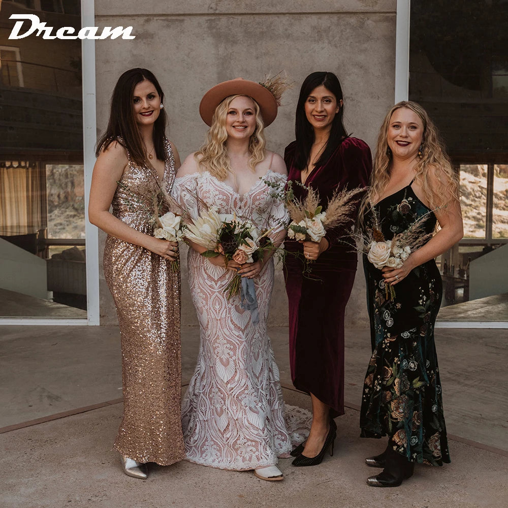 Four women in elegant dresses pose indoors. One in a sequin gown, another in a lace dress with a hat, third in velvet, and the last in a floral dress, all holding bouquets.