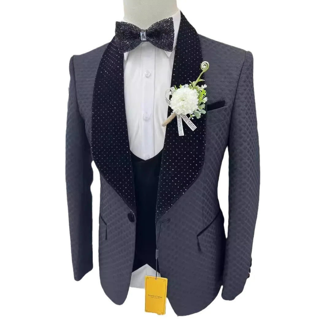 Elegant dark patterned tuxedo with wide shawl lapel and polka-dot details, white dress shirt, matching bow tie, and white boutonniere on the left lapel.