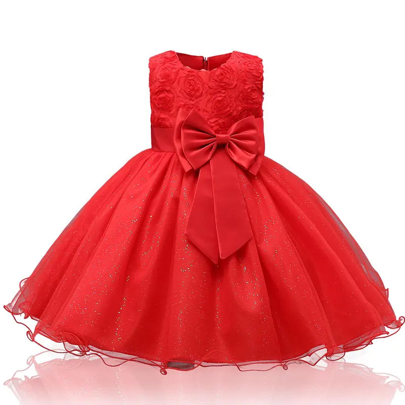 Red girls' dress with floral bodice, large bow at waist, and a sparkling tulle skirt. Sleeveless design with a zipper at the back, perfect for a festive occasion.