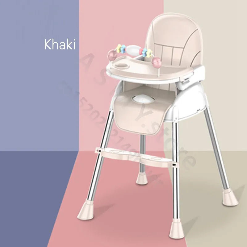 Khaki-colored baby high chair with metal legs, a tray, footrest, and colorful toys on the tray. Background features blocks of mauve, pink, and beige colors.