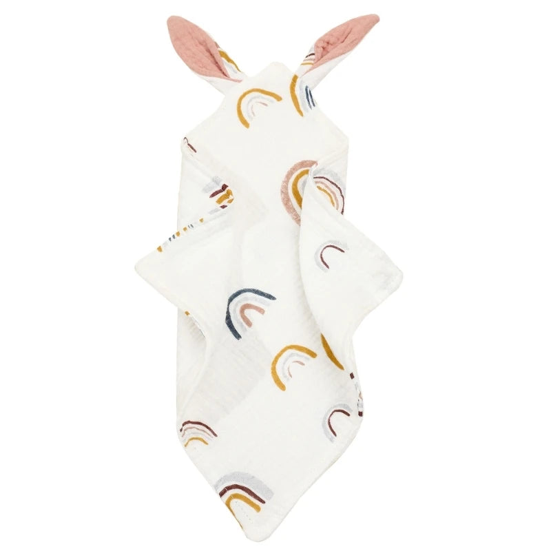 White muslin baby blanket with rainbow patterns and attached pink bunny ears at the top.