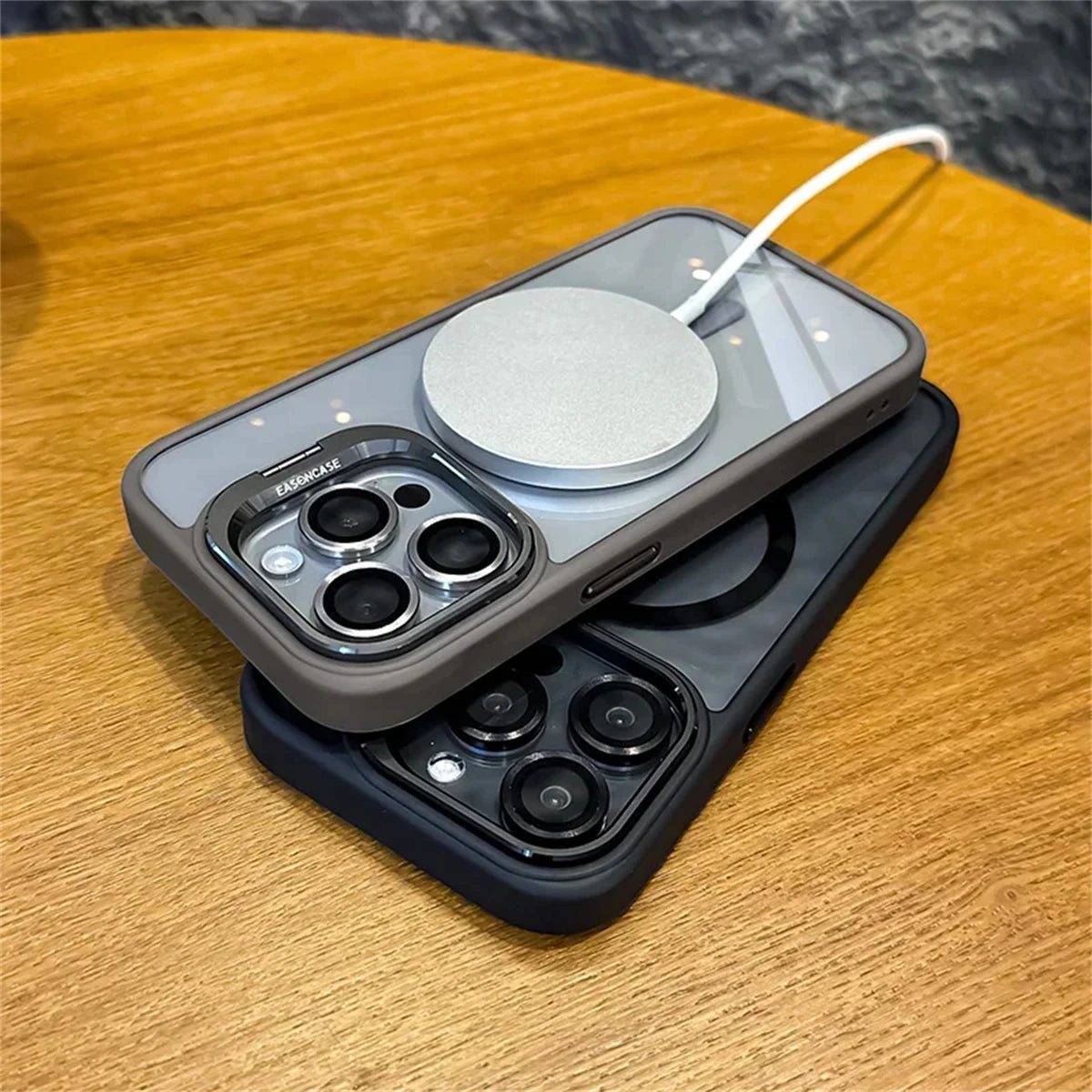 Two smartphones with multilengle camera lens setup on a wooden table. One phone is charging wirelessly with a circular pad attached to its back.