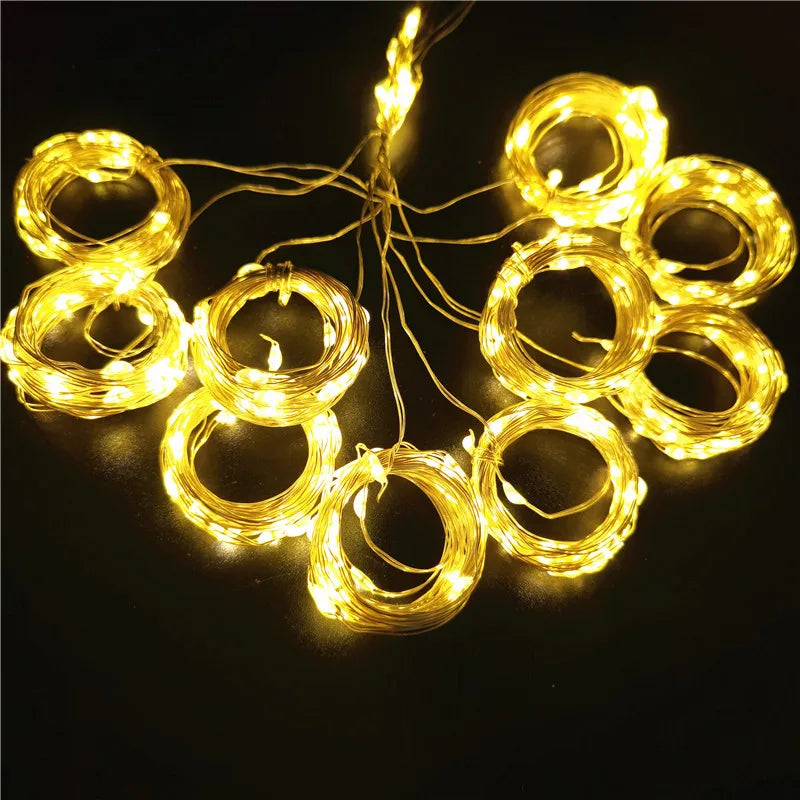 Coiled strings of warm white fairy lights arranged in a circular pattern on a dark surface, creating a glowing, festive display.