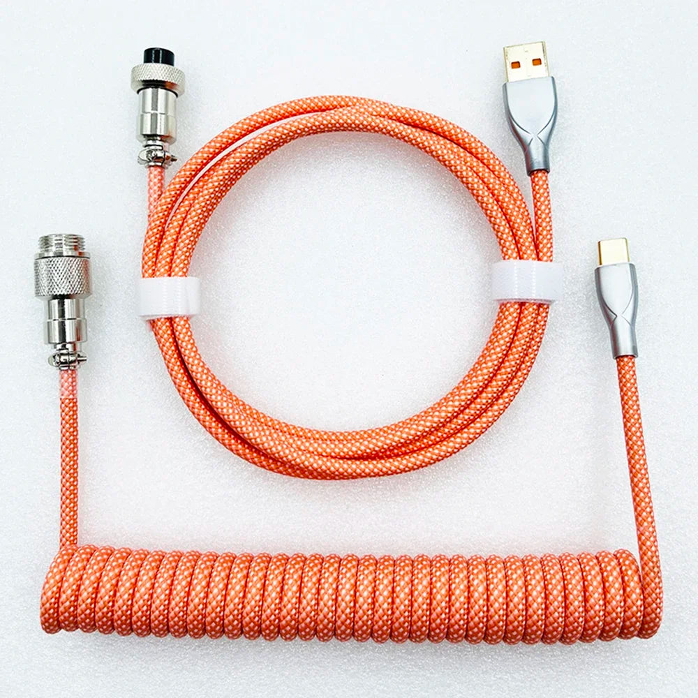 Orange coiled USB cable set with silver connectors, including a coiled section and straight length secured by white clips, against a light background.