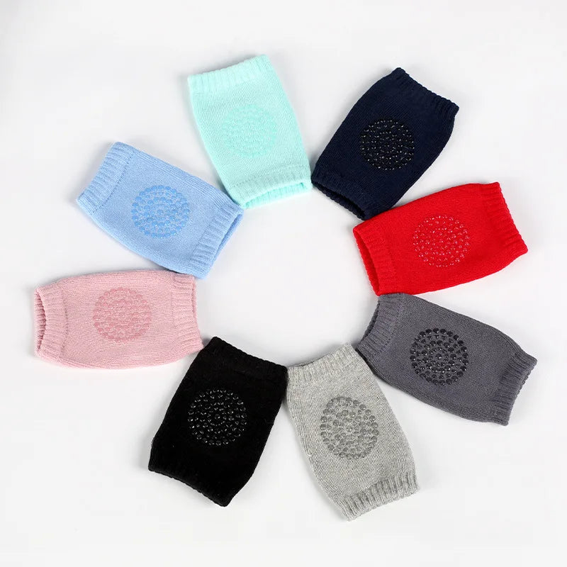 Eight colorful knee pads in a circle arrangement on a white background. Colors include light blue, teal, navy, red, gray, black, pink, and light gray, each with a textured dot pattern.