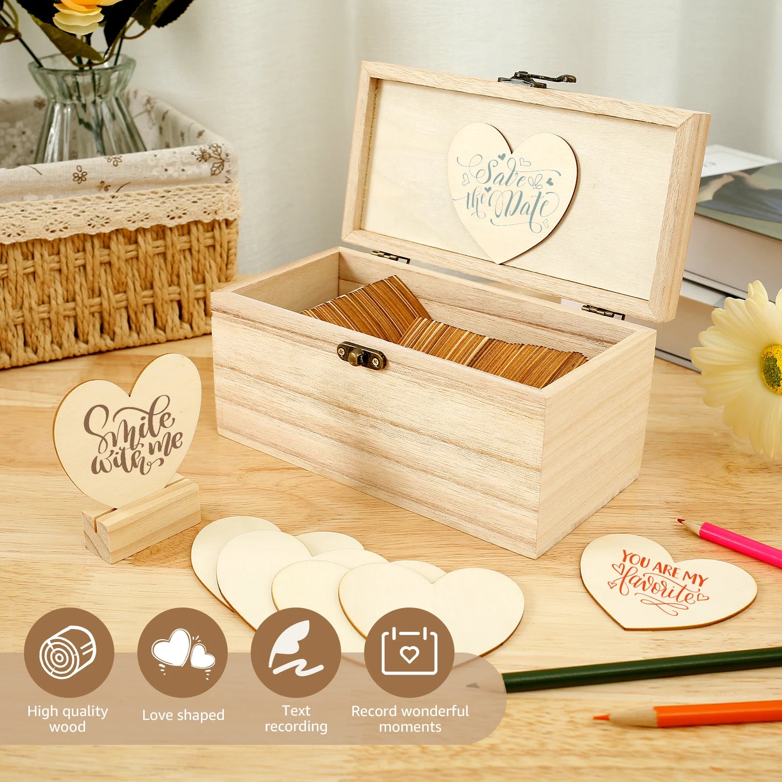 Wooden box with heart-shaped wooden cards for notes. One card says "Smile with me." Nearby, a flower, basket, and colored pencils are arranged on a wooden table.