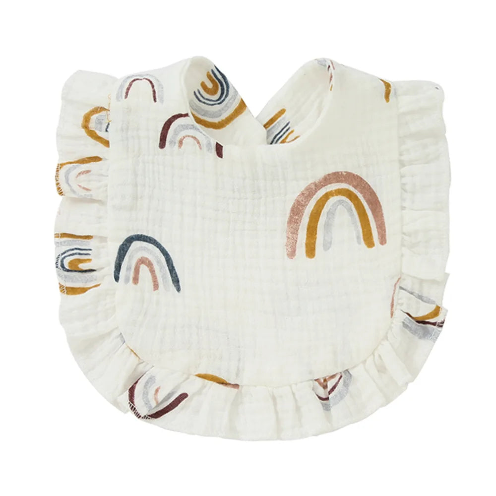 A white baby bib with colorful rainbow patterns in muted tones, featuring ruffled edges and a soft, textured fabric for a cozy and stylish look.