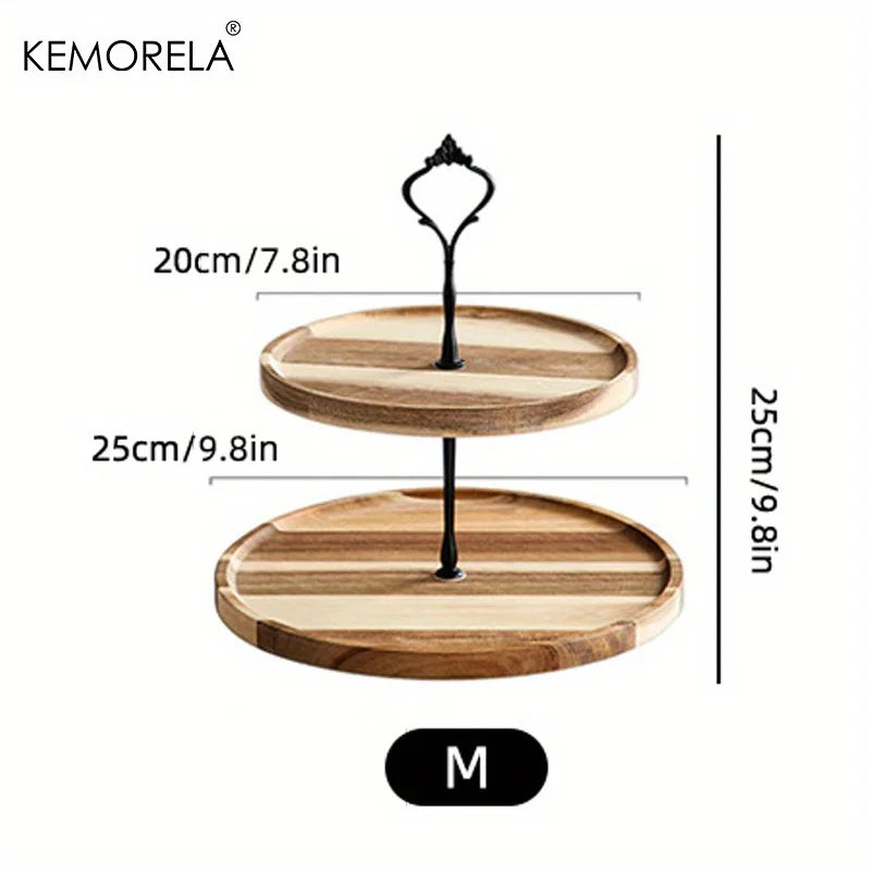 Two-tiered wooden serving tray with black handle. Top tray is 20cm, bottom tray is 25cm, and total height is 25cm, labeled size M. Brand name "Kemorela" at top left.
