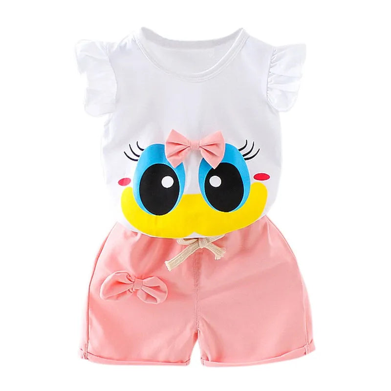 Cute baby outfit with a white flutter sleeve top featuring a cartoon face with big eyes and a pink bow. Matching pink shorts have a bow on the side and a ribbon tie.
