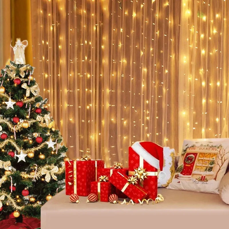 A festive scene with a decorated Christmas tree, red and gold wrapped gifts, a Santa hat, and a pillow against a backdrop of warm, glowing string lights on a curtain.