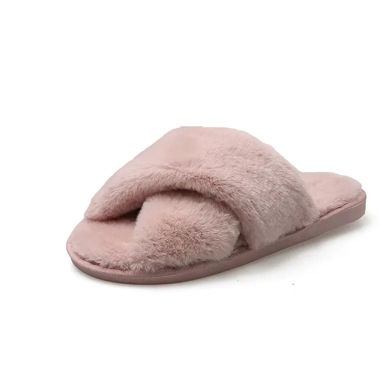 Pink faux fur slipper with a plush crisscross design over the foot bed, featuring a soft sole.