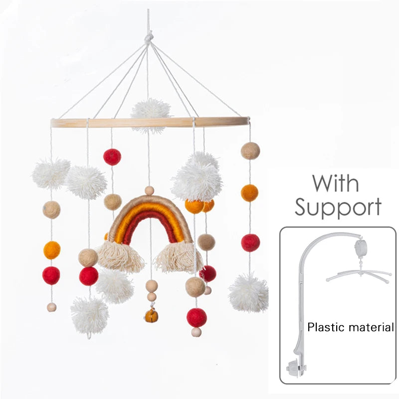 Colorful baby mobile featuring a rainbow, pom-poms, and felt balls in red, orange, and beige. Includes a plastic support arm for hanging.