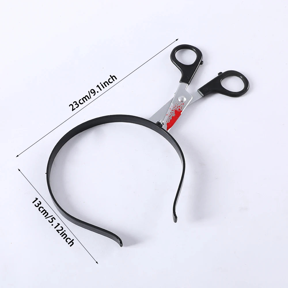 A headband featuring realistic scissors with red paint detail, measuring 23cm in length. The headband's arc is 13cm high, set against a white background.