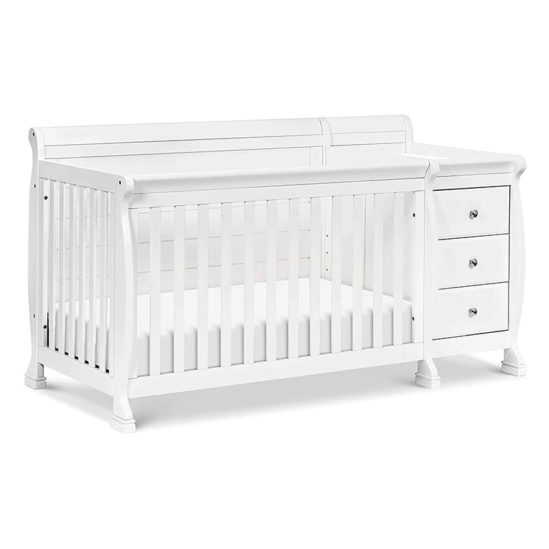White wooden baby crib with slatted sides and an attached dresser featuring three drawers, each with a round silver knob, designed in a classic elegant style.