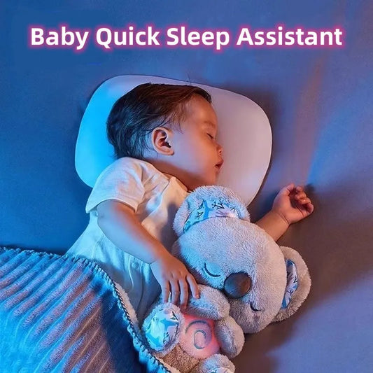 A baby sleeps peacefully on a white pillow, hugging a plush koala under a blue blanket. The image is captioned "Baby Quick Sleep Assistant" in pink text at the top.