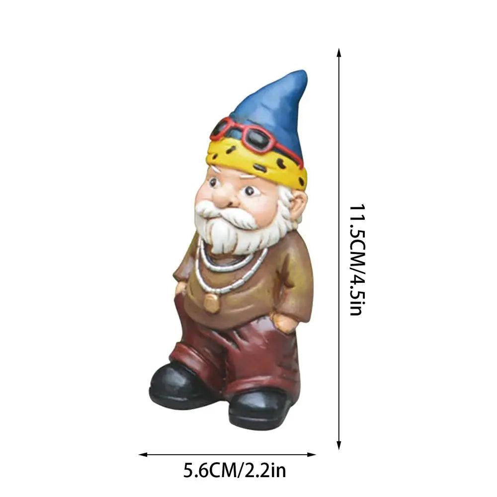 A small garden gnome figurine with a blue hat, yellow bandana, and sunglasses. The bearded gnome measures 11.5 cm tall and 5.6 cm wide, wearing a brown outfit with necklaces.