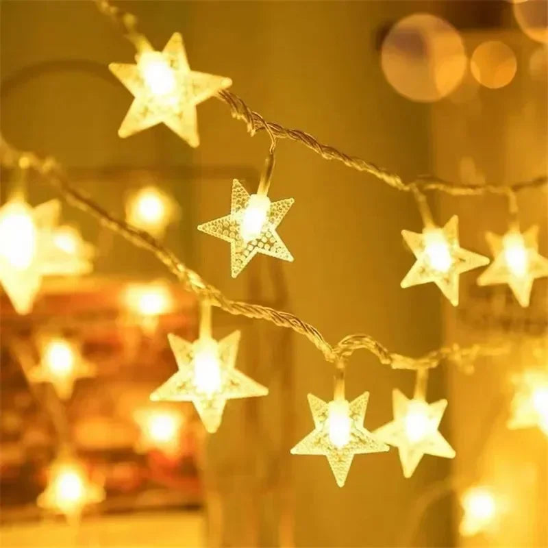 Warm, glowing star-shaped string lights hanging against a blurred background, creating a cozy and festive ambiance with their soft yellow illumination.