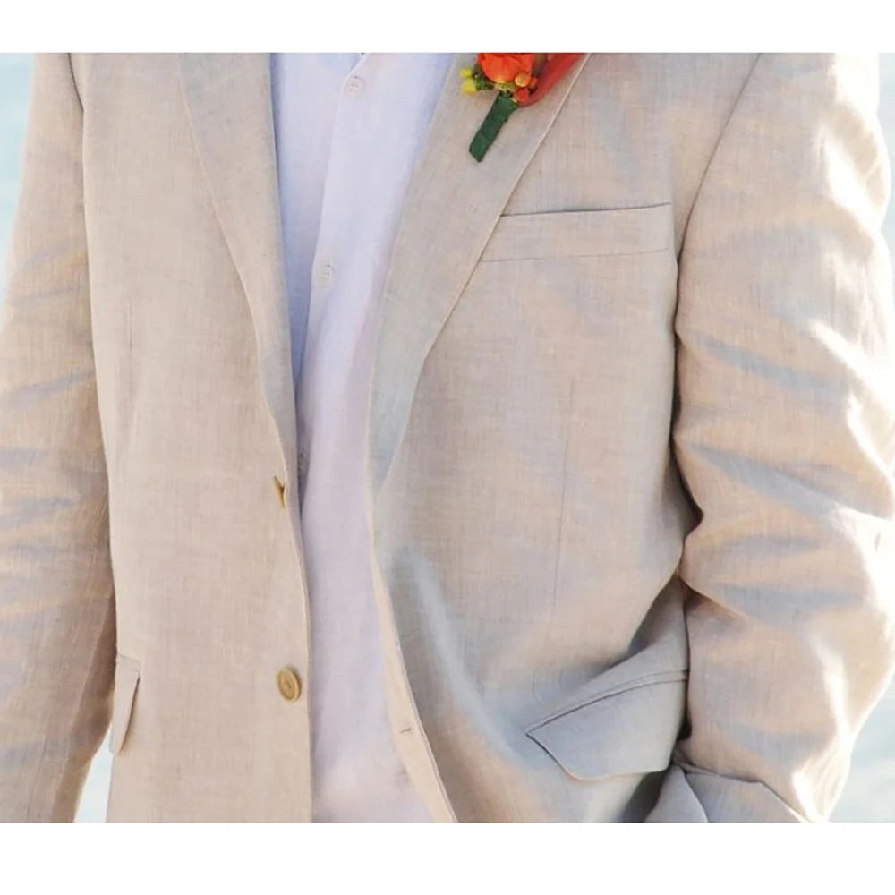 Man in a beige linen suit with a white shirt, adorned with an orange boutonniere. His hand is in his pocket, suggesting a casual, yet formal stance.