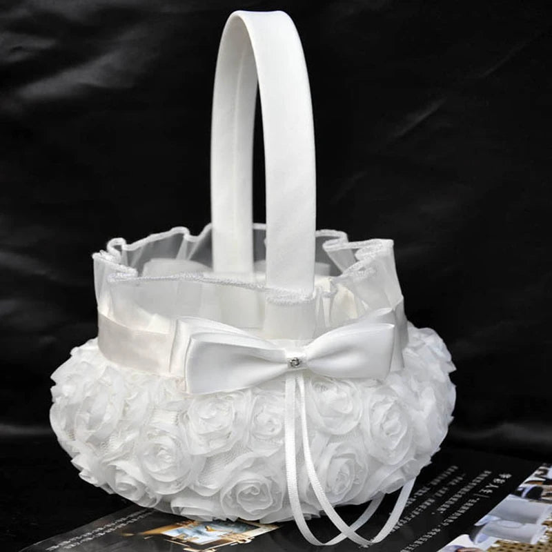 Elegant white basket with a handle, adorned with rosette fabric and a satin bow, against a dark background. Ideal for weddings or special occasions.