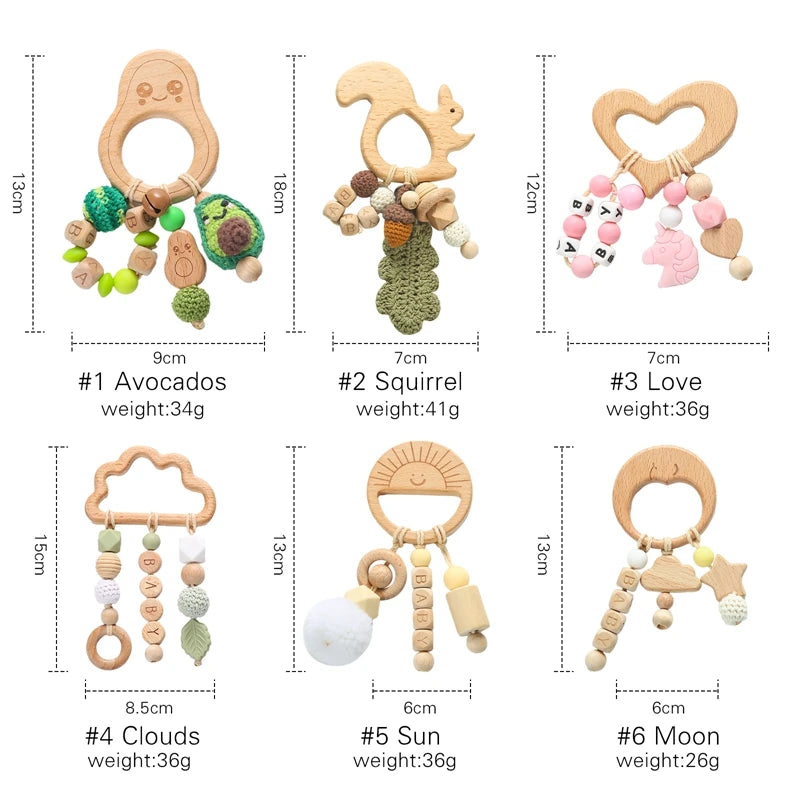 Six wooden baby teether toys with different themes: Avocados, Squirrel, Love, Clouds, Sun, Moon. Each includes knit elements and beads spelling "BABY," with varied sizes and weights.