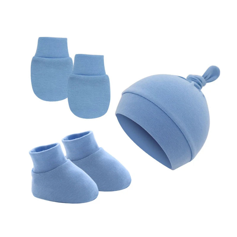 Blue baby set including a knotted beanie, a pair of mittens, and booties, all made of soft fabric.