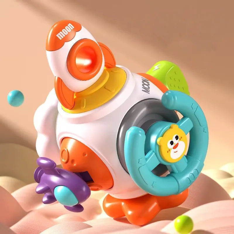 Colorful children's toy with a spaceship, steering wheel, and animal face. Features orange, yellow, turquoise elements, and planets. Set on a soft, pastel background.