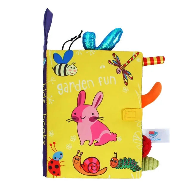 Colorful children's cloth book titled "Garden Fun" featuring illustrations of a pink rabbit, bee, dragonfly, snails, and caterpillar on a yellow background with textured tabs.