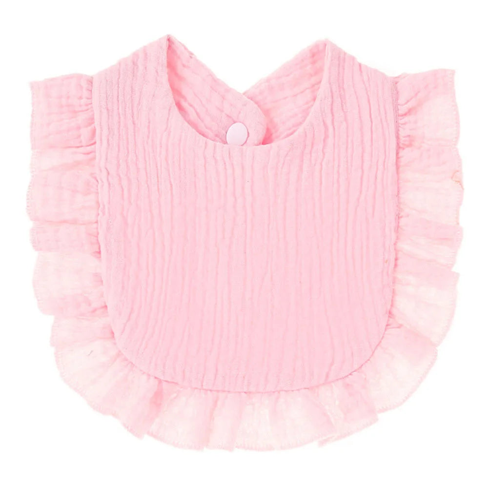 A pink baby bib with a textured fabric and ruffled edges. It features a snap closure at the neckline.