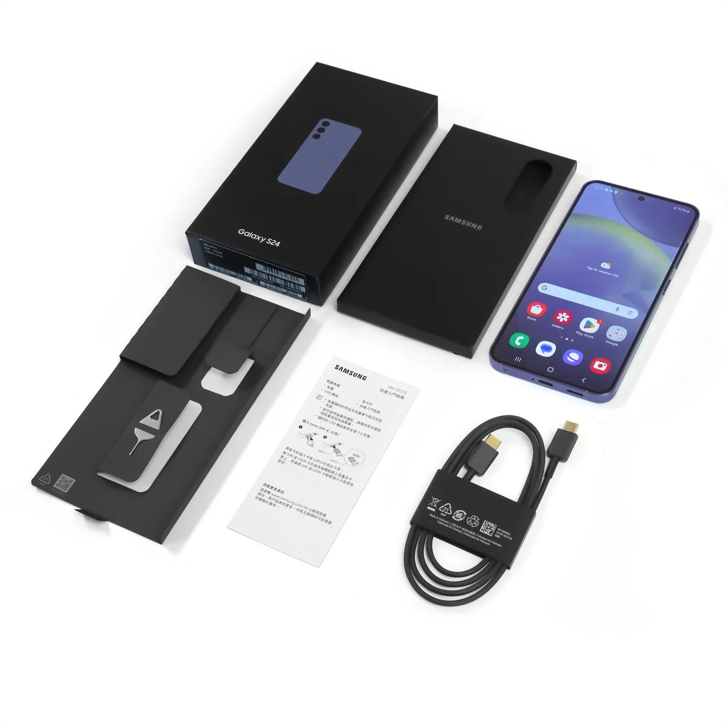 Samsung Galaxy S24 smartphone with box, cable, and instruction manual. The phone screen displays app icons, and the packaging includes a SIM eject tool.