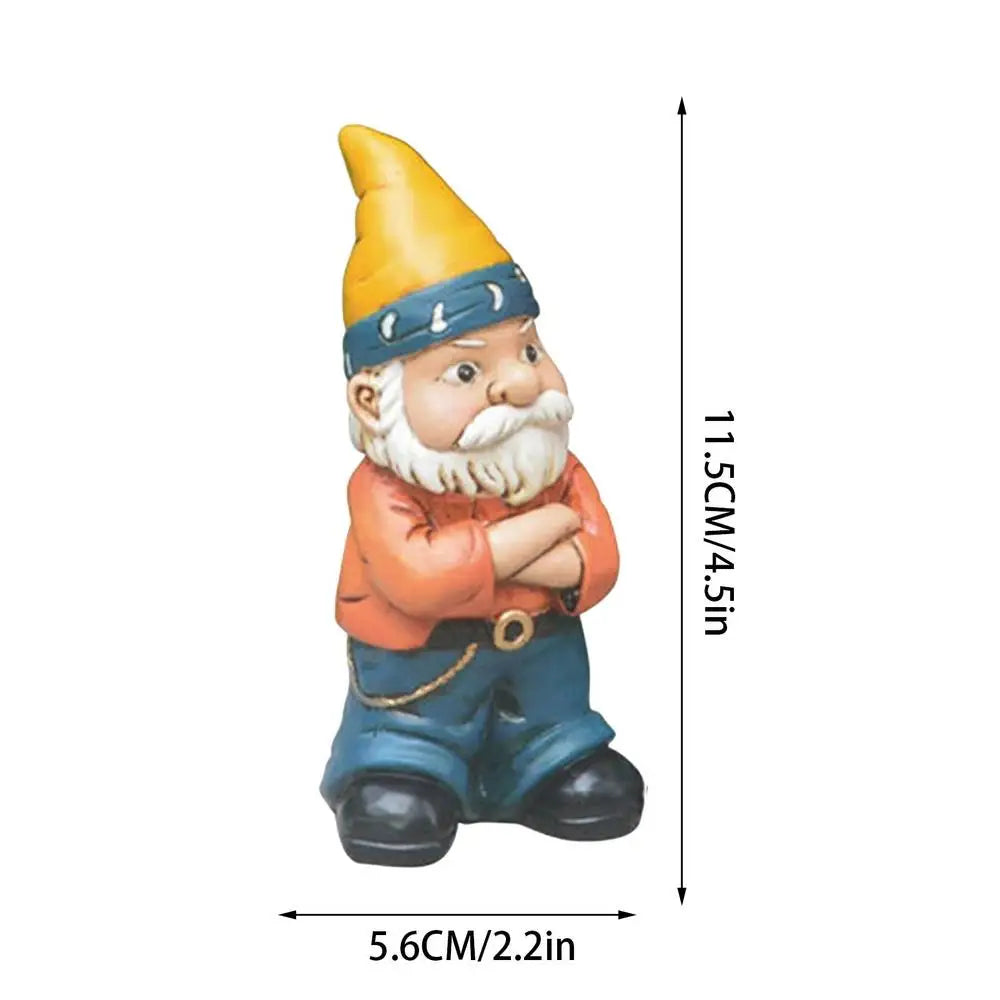 A small garden gnome with a yellow hat, crossed arms, and a blue bandana stands, measuring 11.5 cm (4.5 in) tall and 5.6 cm (2.2 in) wide.