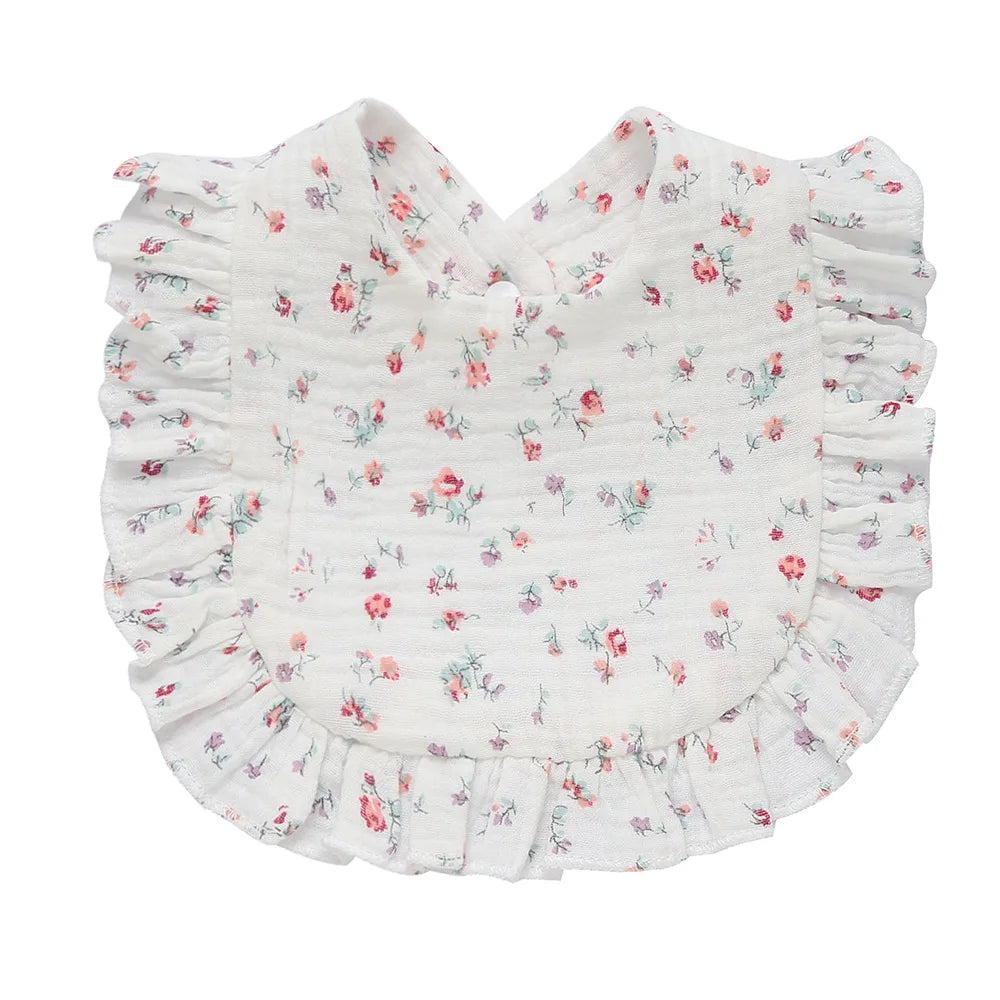Floral baby bib with delicate pink and purple flowers on white fabric, featuring ruffled edges for a charming, elegant touch.