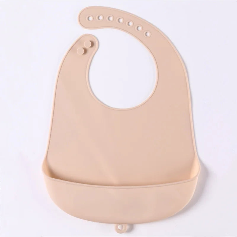 Beige silicone baby bib with adjustable neck strap and a wide food-catching pocket at the bottom, shown on a white background.