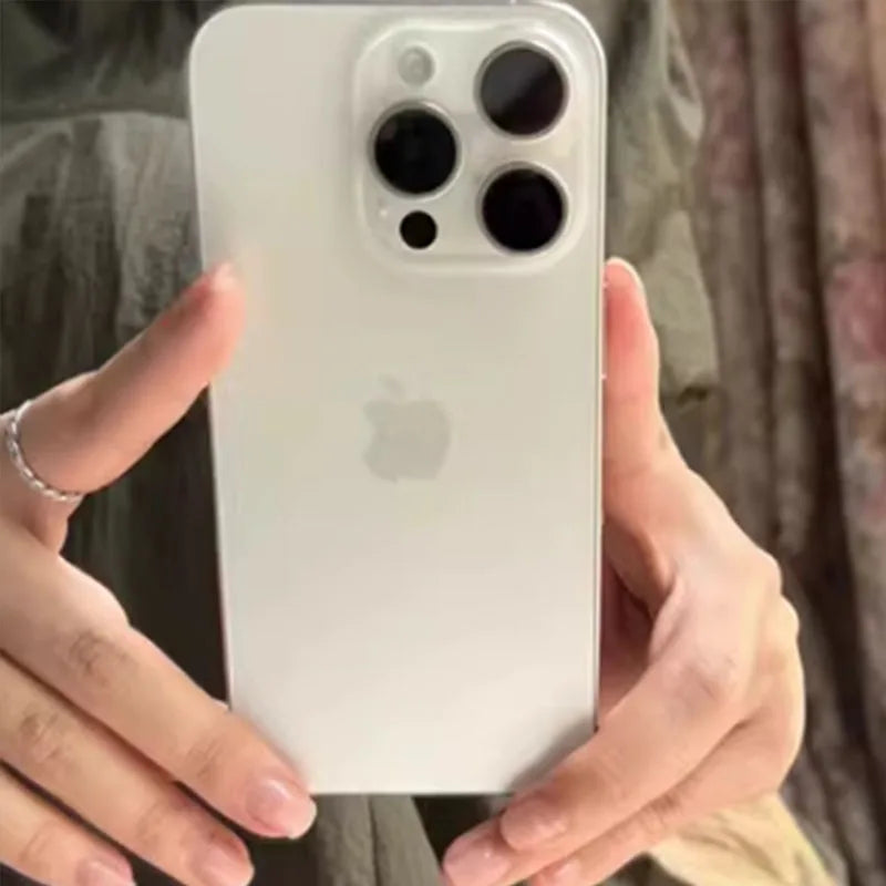 A person holds a silver smartphone with a prominent triple camera and flash on the back, featuring the Apple logo.
