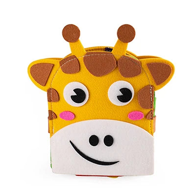 A colorful felt book cover designed as a cheerful giraffe, featuring big eyes, brown spots, and a smiling mouth. The giraffe has two small horns and pink cheeks.