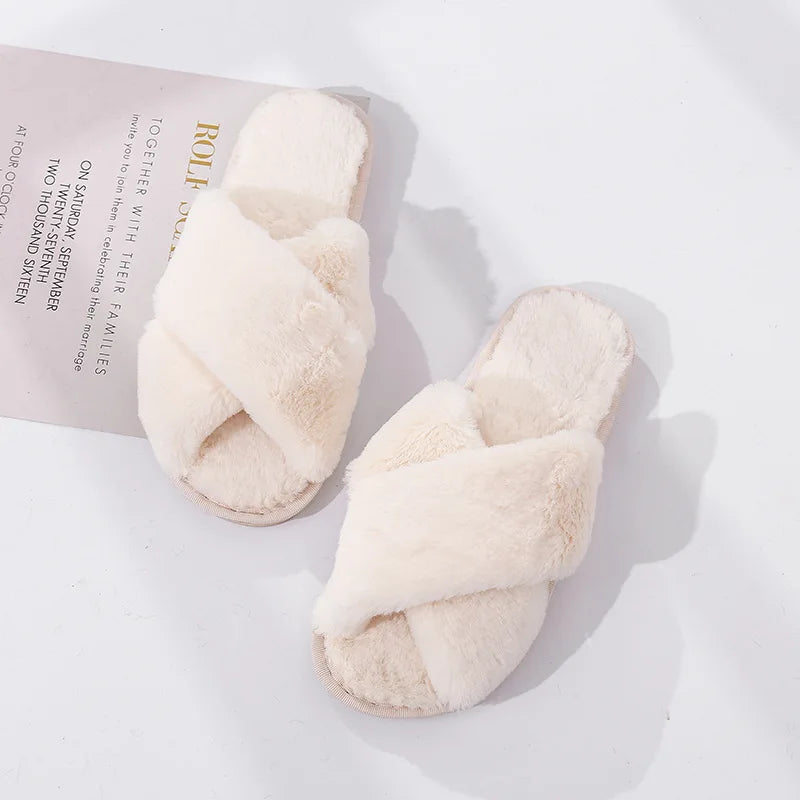 Fluffy cream-colored slippers with crisscross straps sit on a white surface, next to a page with text, creating a cozy, inviting scene.