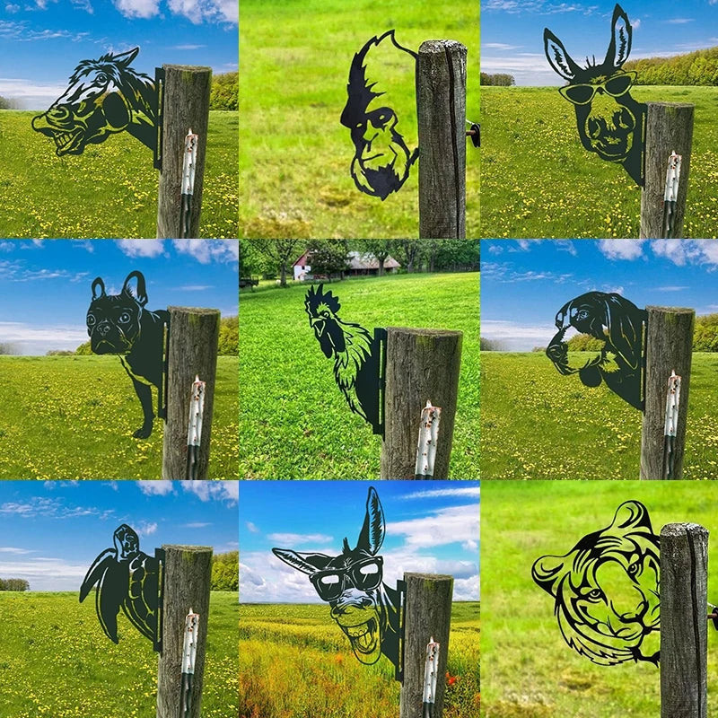 Metal silhouette signs of various animals, including a horse, gorilla, donkey, dog, rooster, and tiger, are attached to wooden posts in a grassy field under a clear sky.
