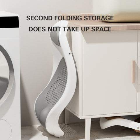 A folded laundry basket is stored beside a washing machine and cabinet. Text reads: "Second folding storage does not take up space." The basket is gray and white with a sleek design.