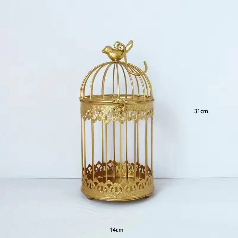 Elegant gold birdcage with a decorative bird on top, measuring 31cm in height and 14cm in diameter. The cage features intricate designs on the base and top.