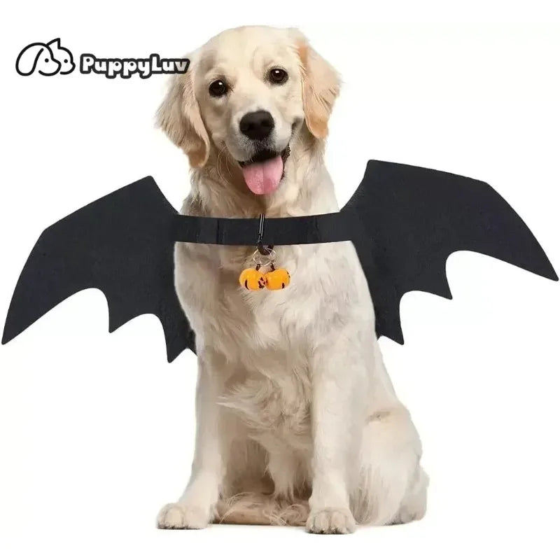 Golden Retriever wearing black bat wings and a pumpkin collar, sitting with tongue out, against a white background. Branding reads "PuppyLuv" in the top left corner.