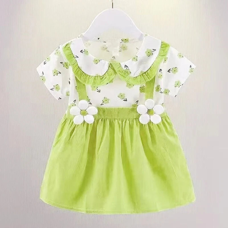 Toddler dress on hanger, featuring a green skirt with daisy accents and a white top with green floral print and ruffled collar.