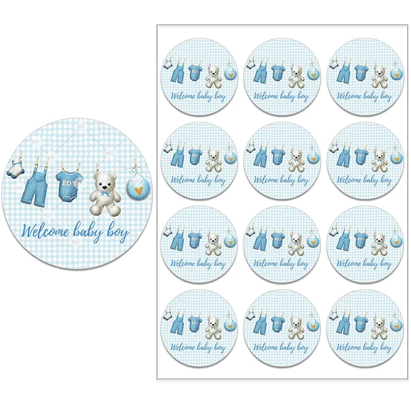 Circular stickers with "Welcome baby boy" text, featuring blue baby clothes, a teddy bear, and a heart on a light blue checkered background. Multiple stickers displayed.