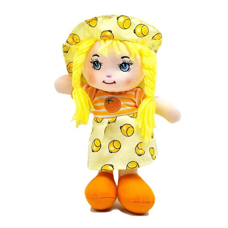 A doll with bright yellow braided hair wearing a matching hat and dress with lemon patterns, orange shoes, and a striped top featuring an orange motif.