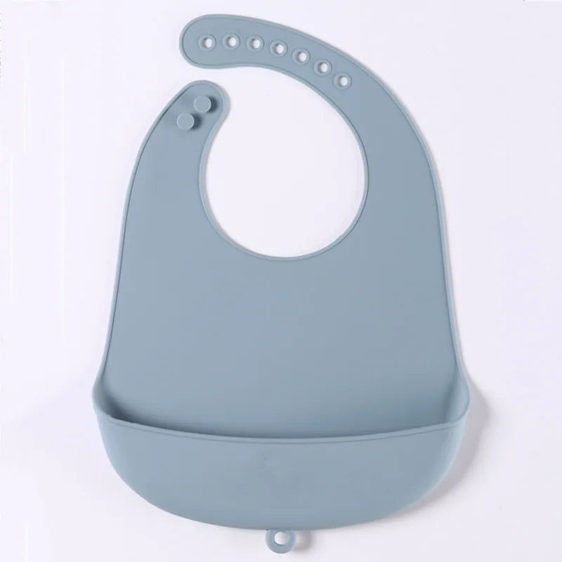 Blue silicone baby bib with adjustable neck strap and a built-in pocket for catching spills. Designed with multiple snap buttons for sizing.